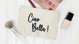 Beige pouch with 'Ciao Bella!' text, makeup brush, and nail polish on a white background