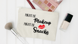 A canvas makeup bag with the text 'MIGHT BE Makeup Snacks' and a red lips graphic, styled on a white paneled background with makeup items around it.