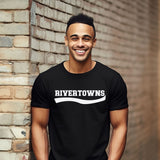 A smiling man wearing a black short-sleeve t-shirt with 'RIVERTOWNS' printed in white across the chest, standing against a brick wall.